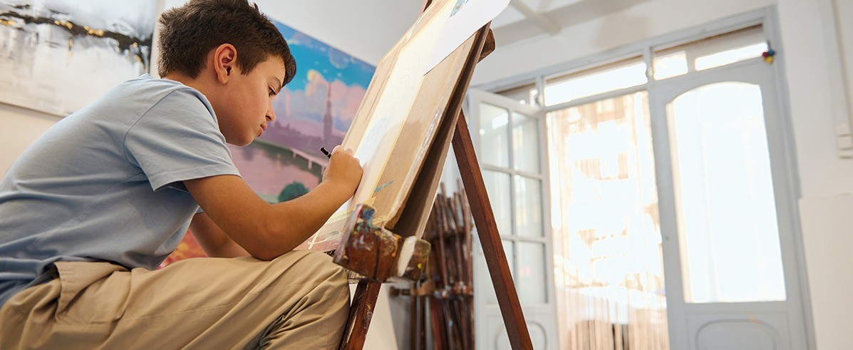w-1197h-491-fa1214-Destination_mp65078855-young-boy-drawing-on-easel-in-art-class-workshop.jpg