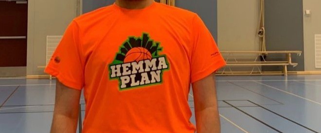 Hemmaplan Kristianstads logga på en orange t-shirt i en idrottshall