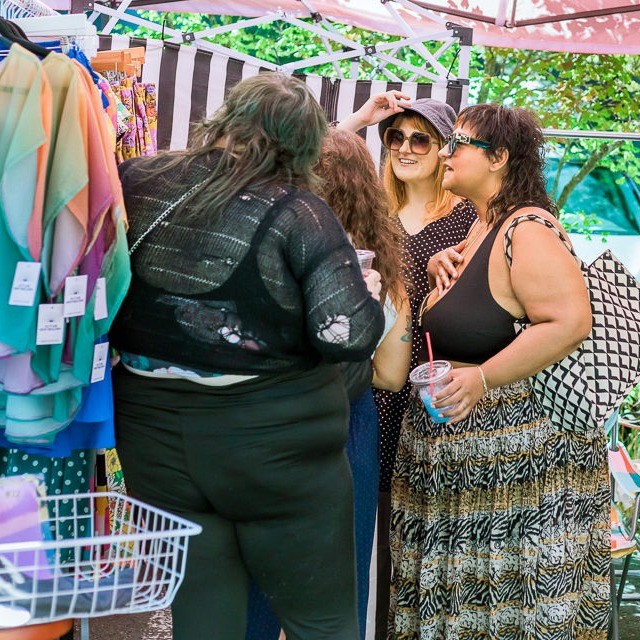 people shopping at a booth in an outdoor market