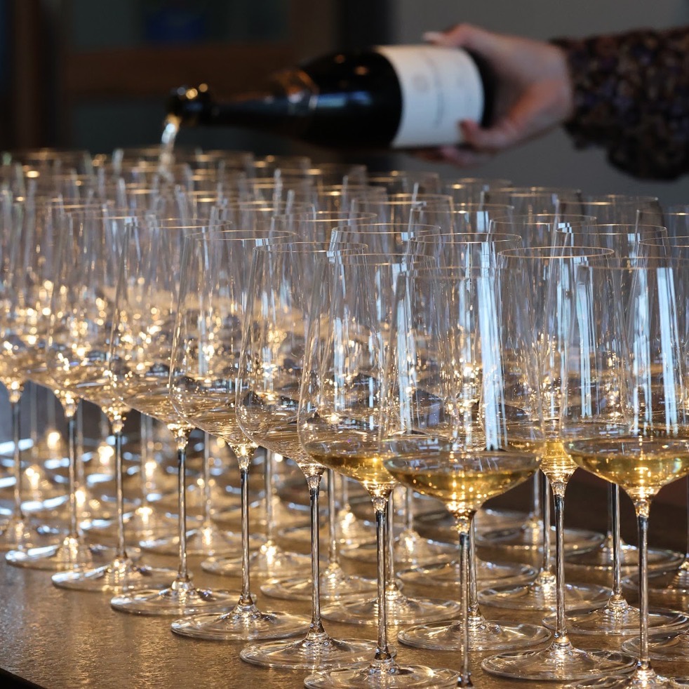 Pouring sparkling wine into dozens of glasses