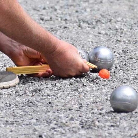 a person measuring the distance between balls on the ground