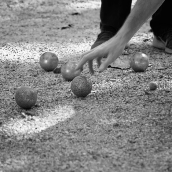 a hand picking up a ball off the ground