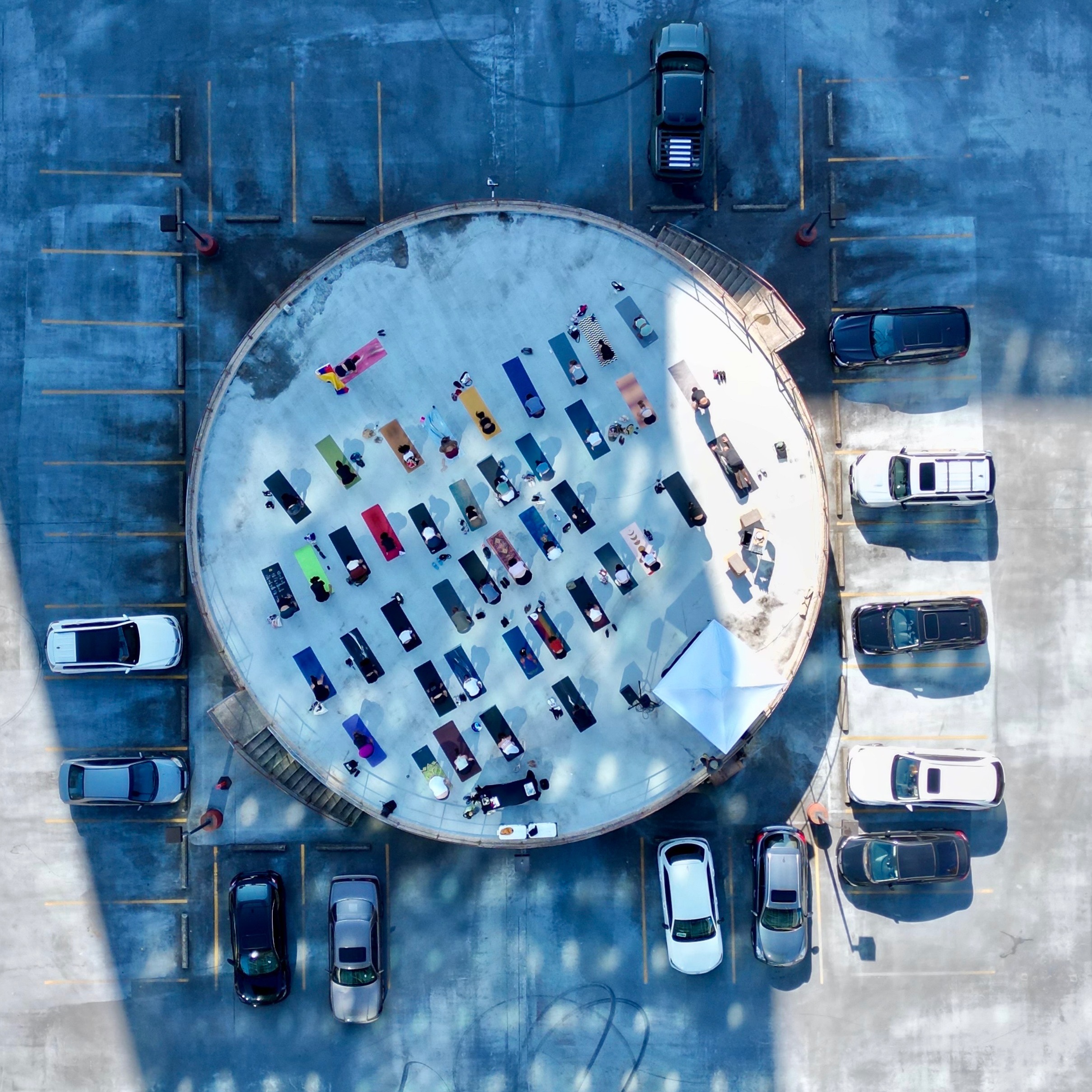 image from above of people on yoga mats on a roof