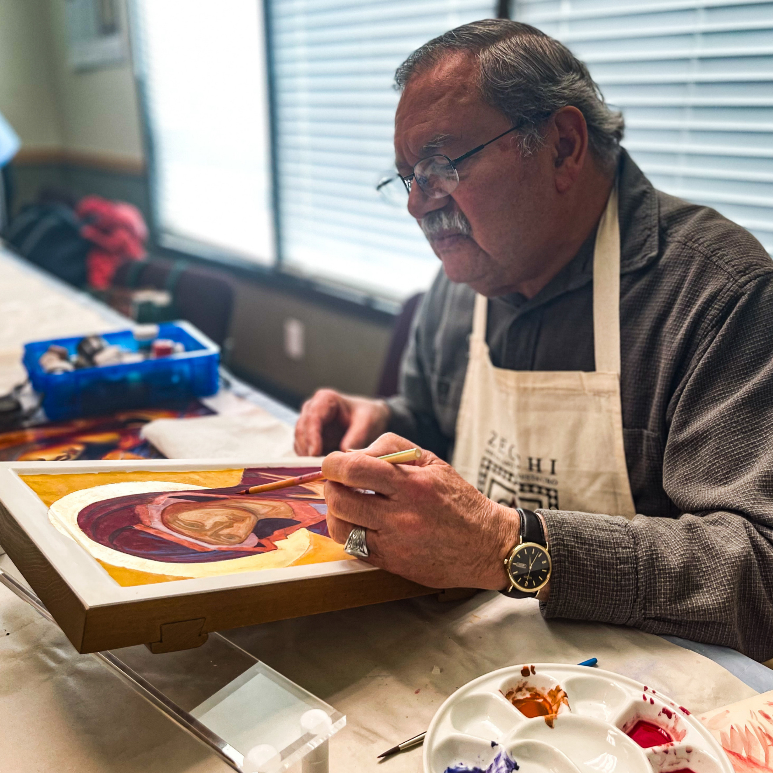 a man painting an image of Mary