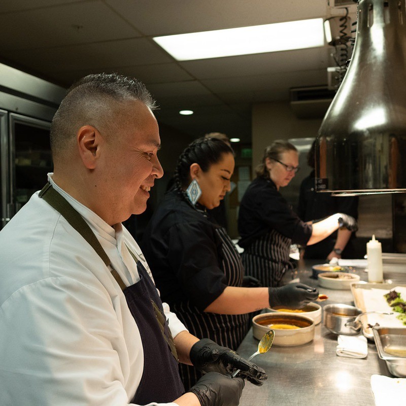 Chef Jack Strong with two members of his culinary team plating dishes.