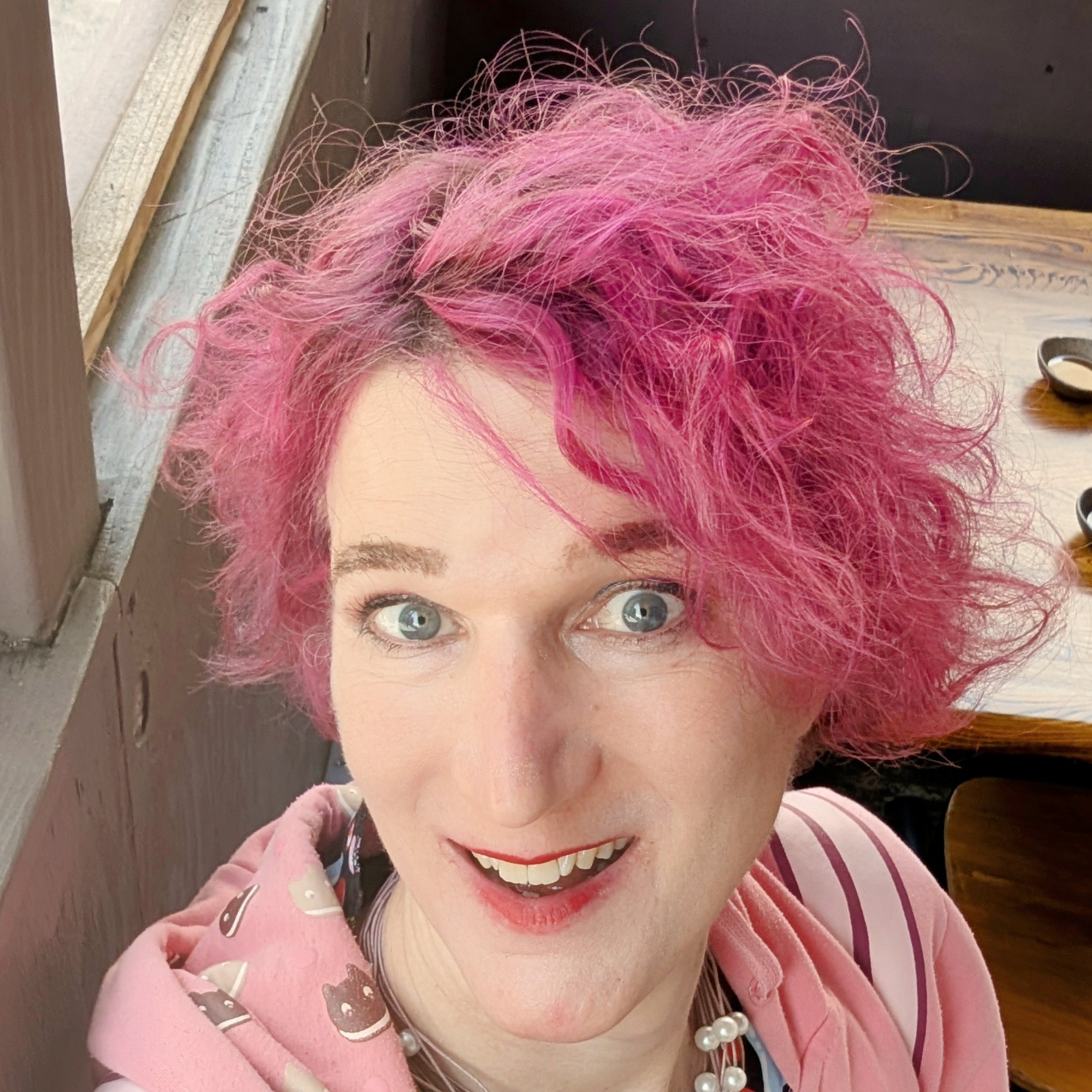 headshot of a woman with pink hair