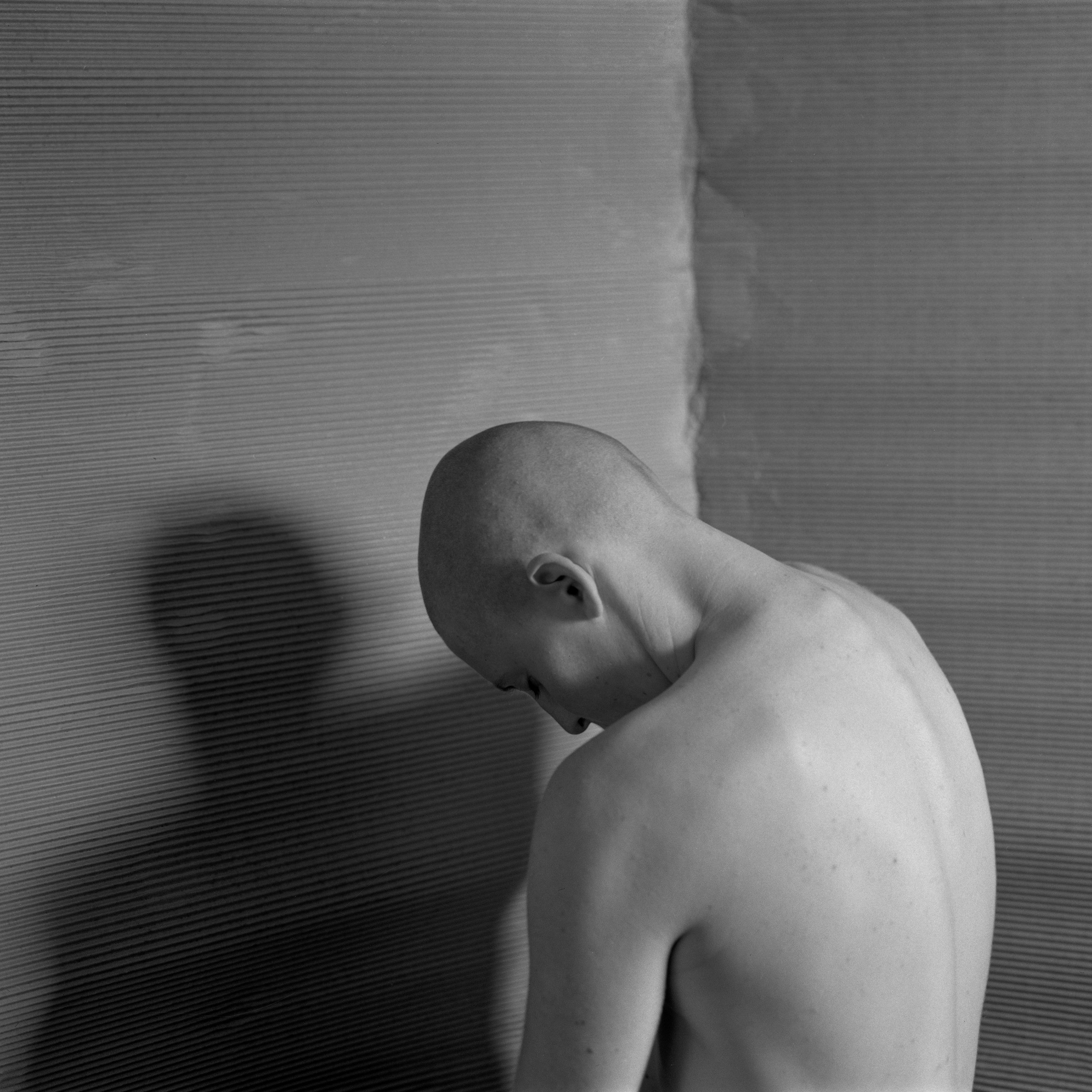 a person standing facing the corner curled in