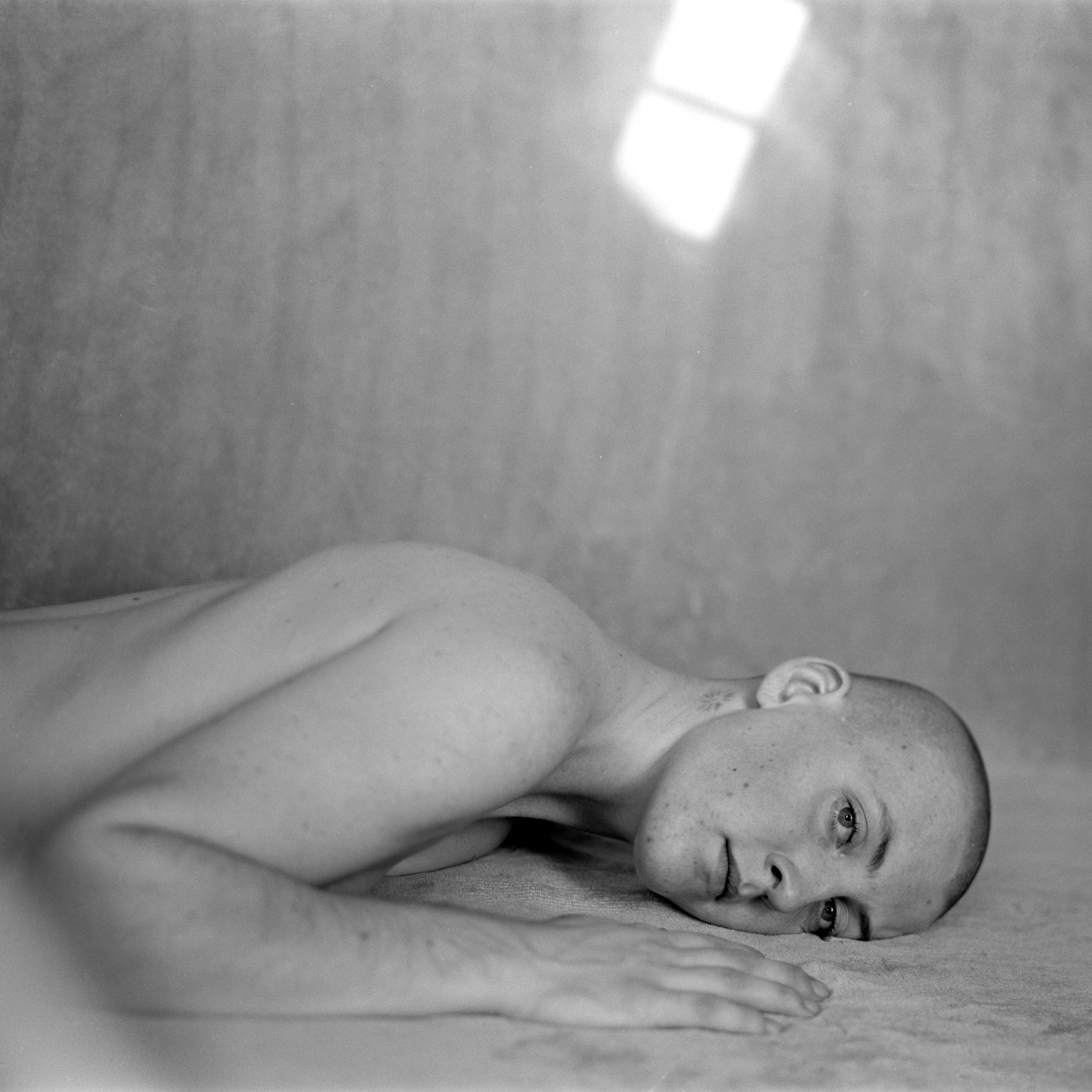 a person lying on the ground looking at the camera