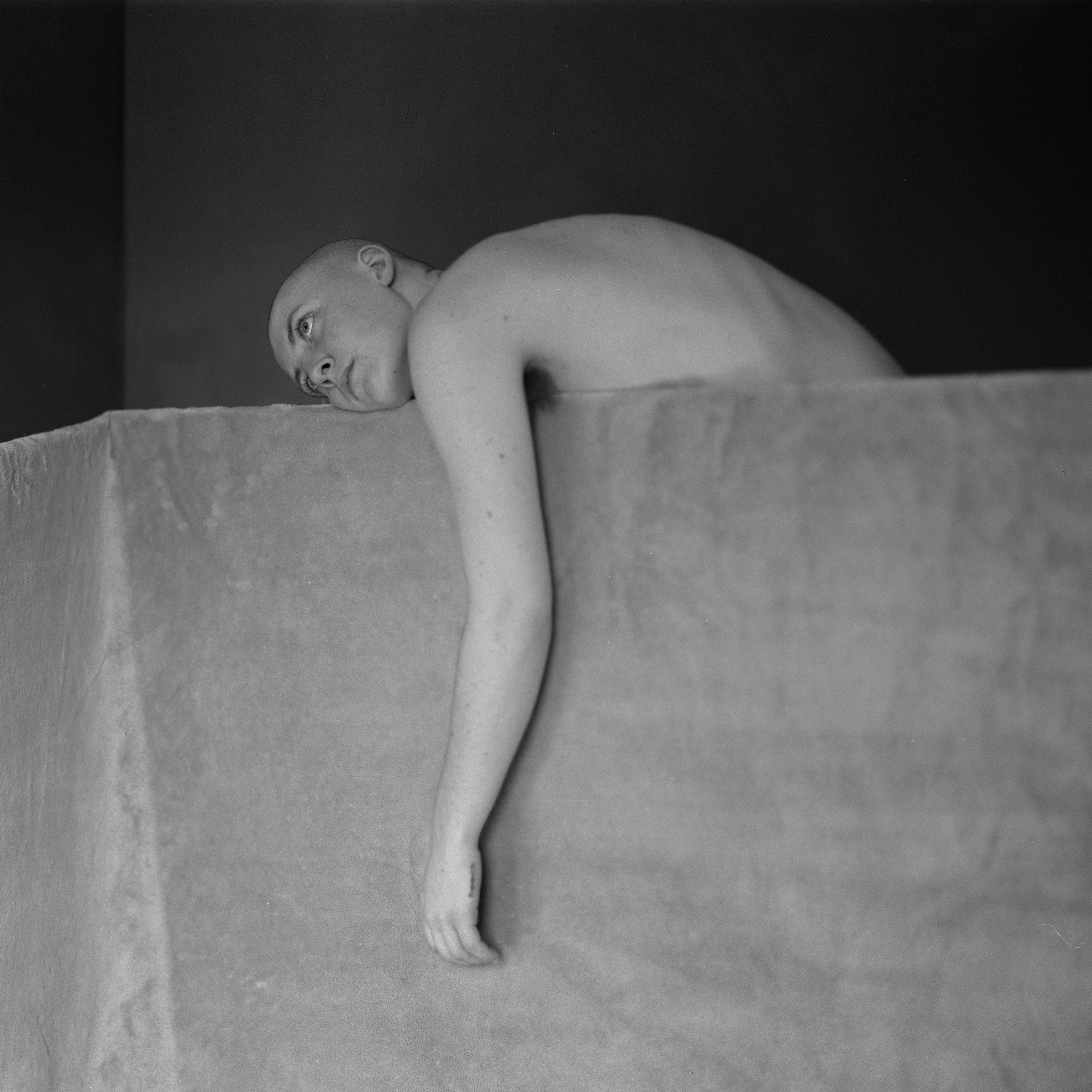 a person lying on the top of a wall with an arm hanging down