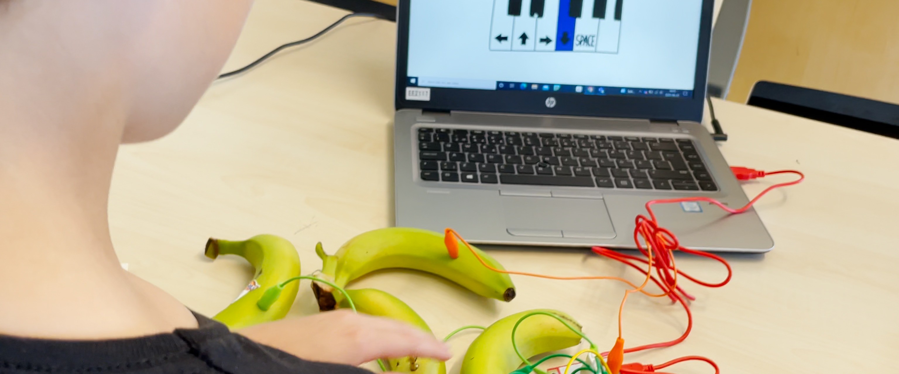 Person tittar på datorn och använder bananer för programmering.