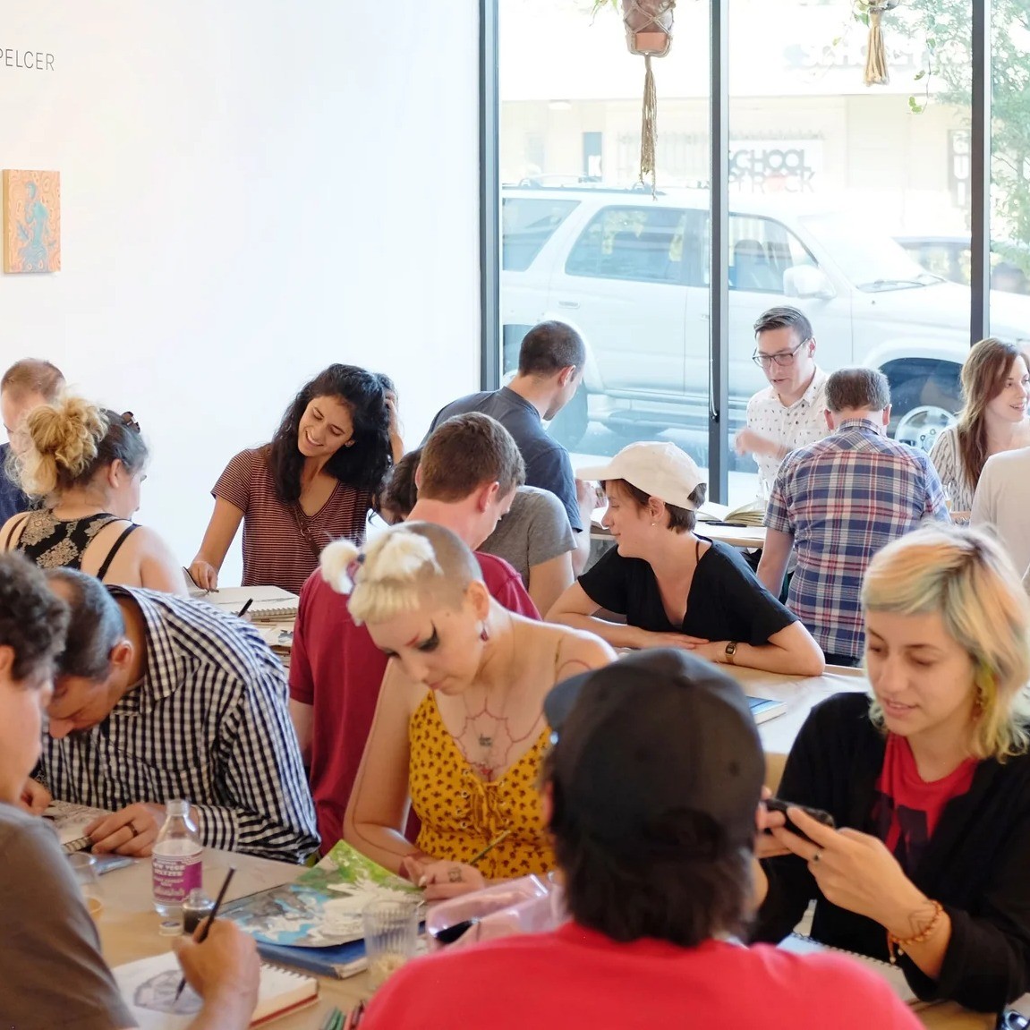 people sit at several tables drawing together
