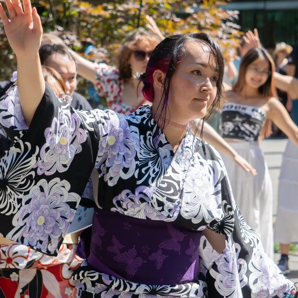 a woman in traditional clothing leads a dance