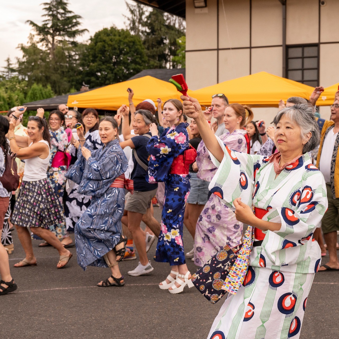 many people joining in dance led by instructor intraditional Japanese costumes