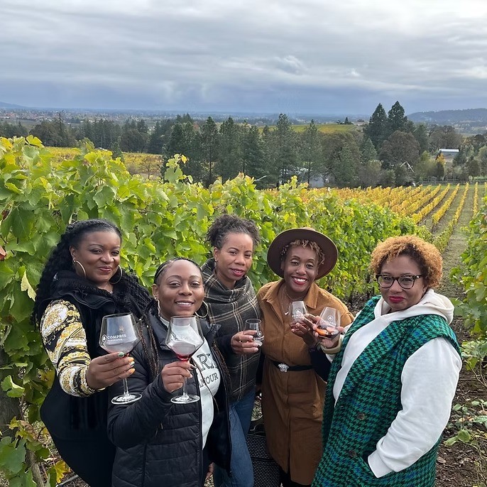 people standing in front of fields of grapes