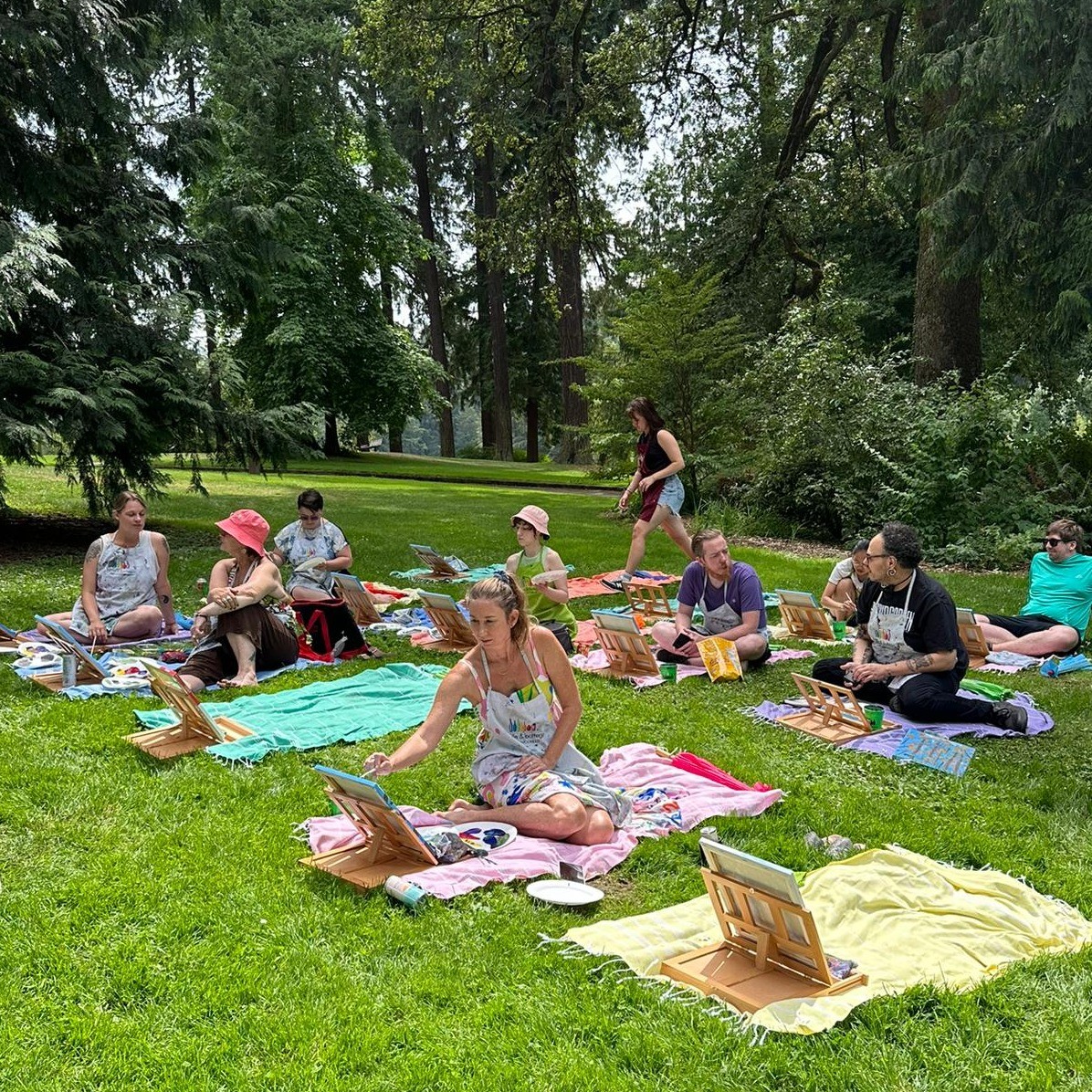 people sitting on blankets and painting