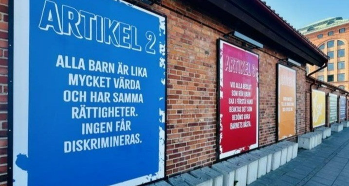 Bilden visar utdrag från utställanden. Men bilder i glada färger och med utdrag från barnkonventionens artiklar på en tegelvägg.  