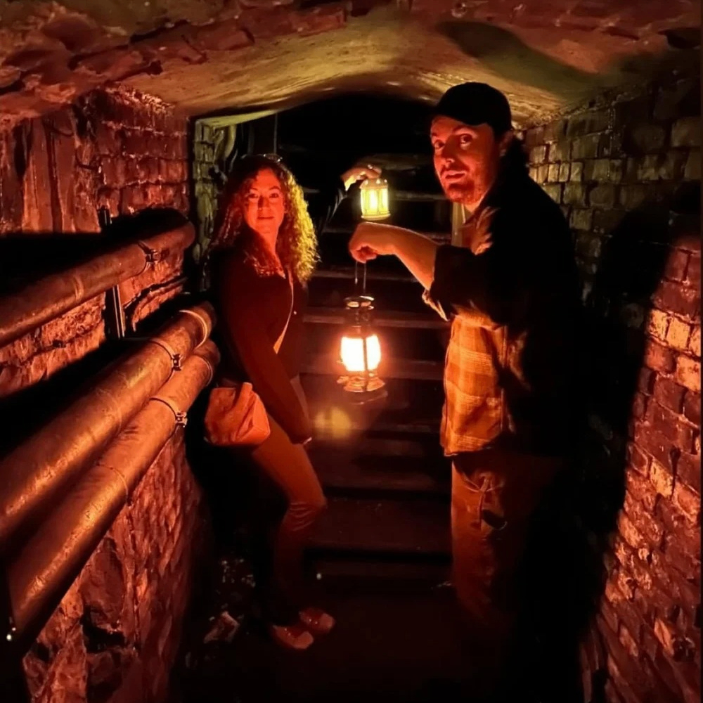 people carrying lanterns in underground tunnels