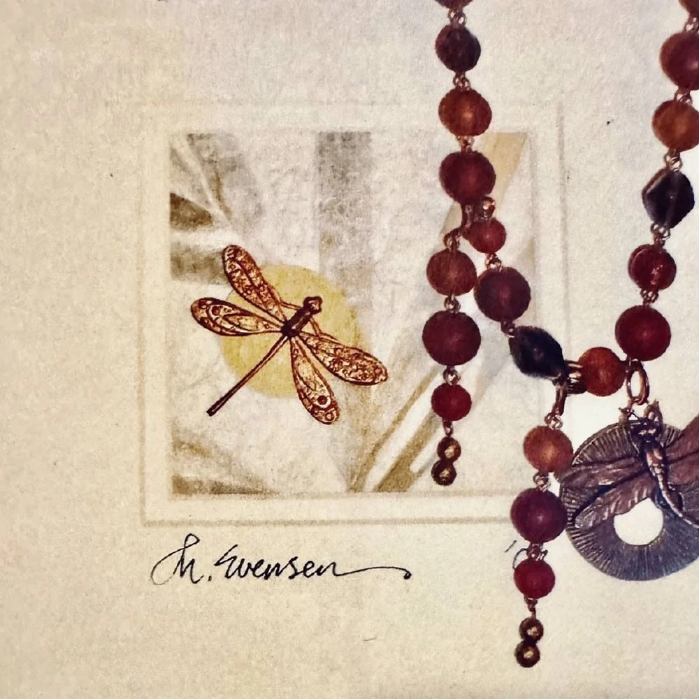 a beaded necklace with a dragon fly pendant