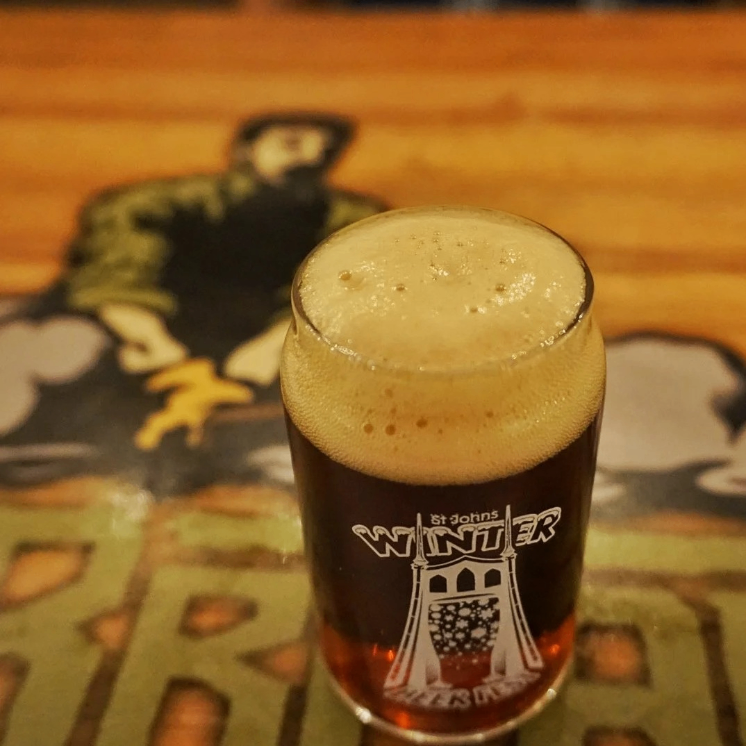 a frothy beer in a glass sitting on a table