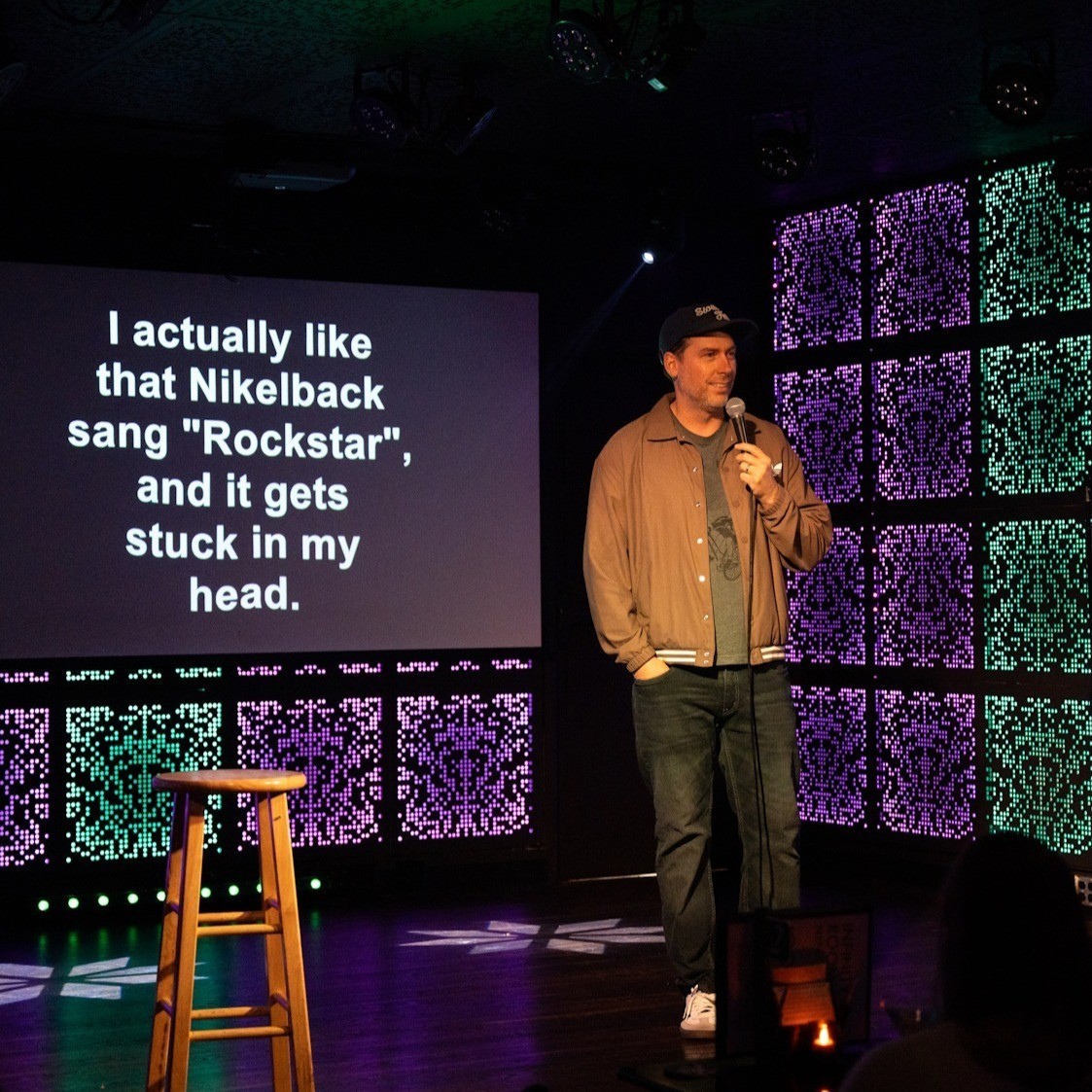 person on stage speaking into a microphone