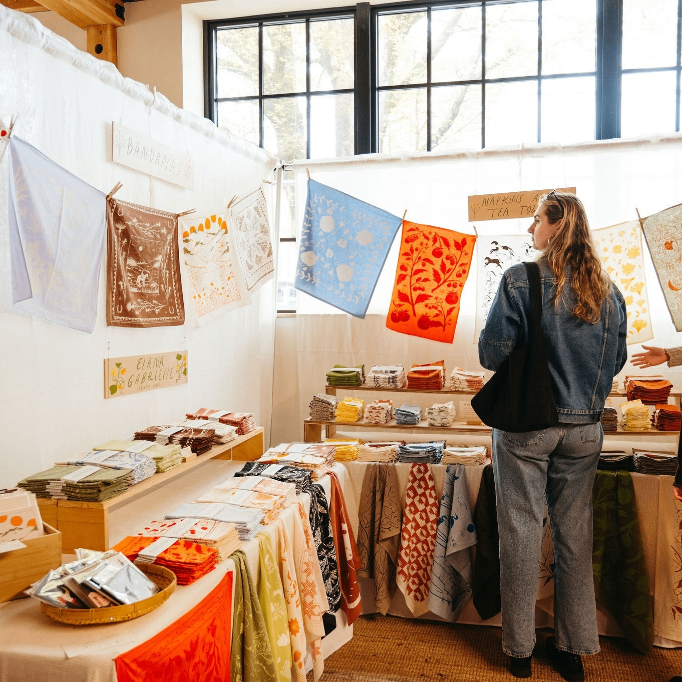 a person perusing textile art at a market