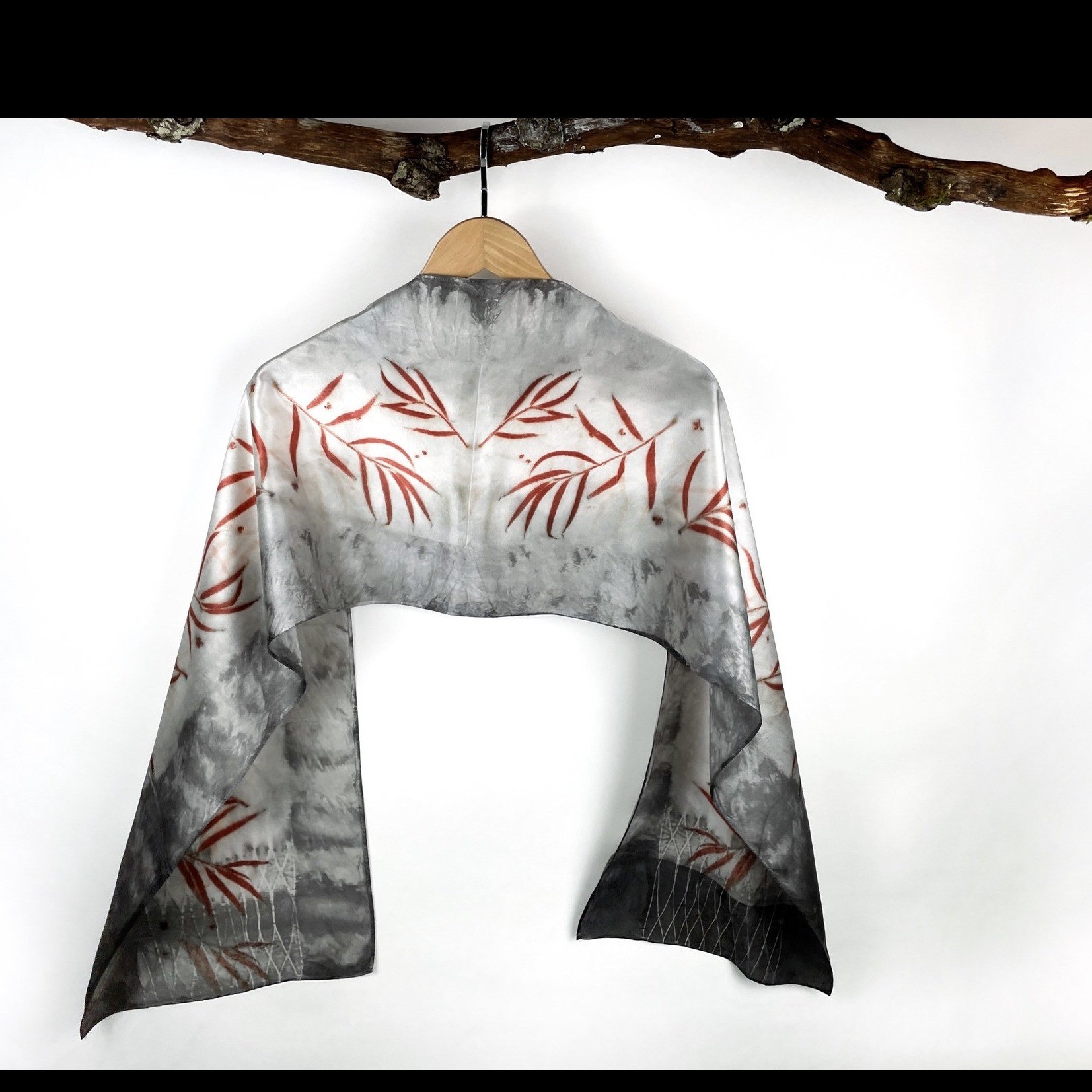 a scarf with a red leaf pattern