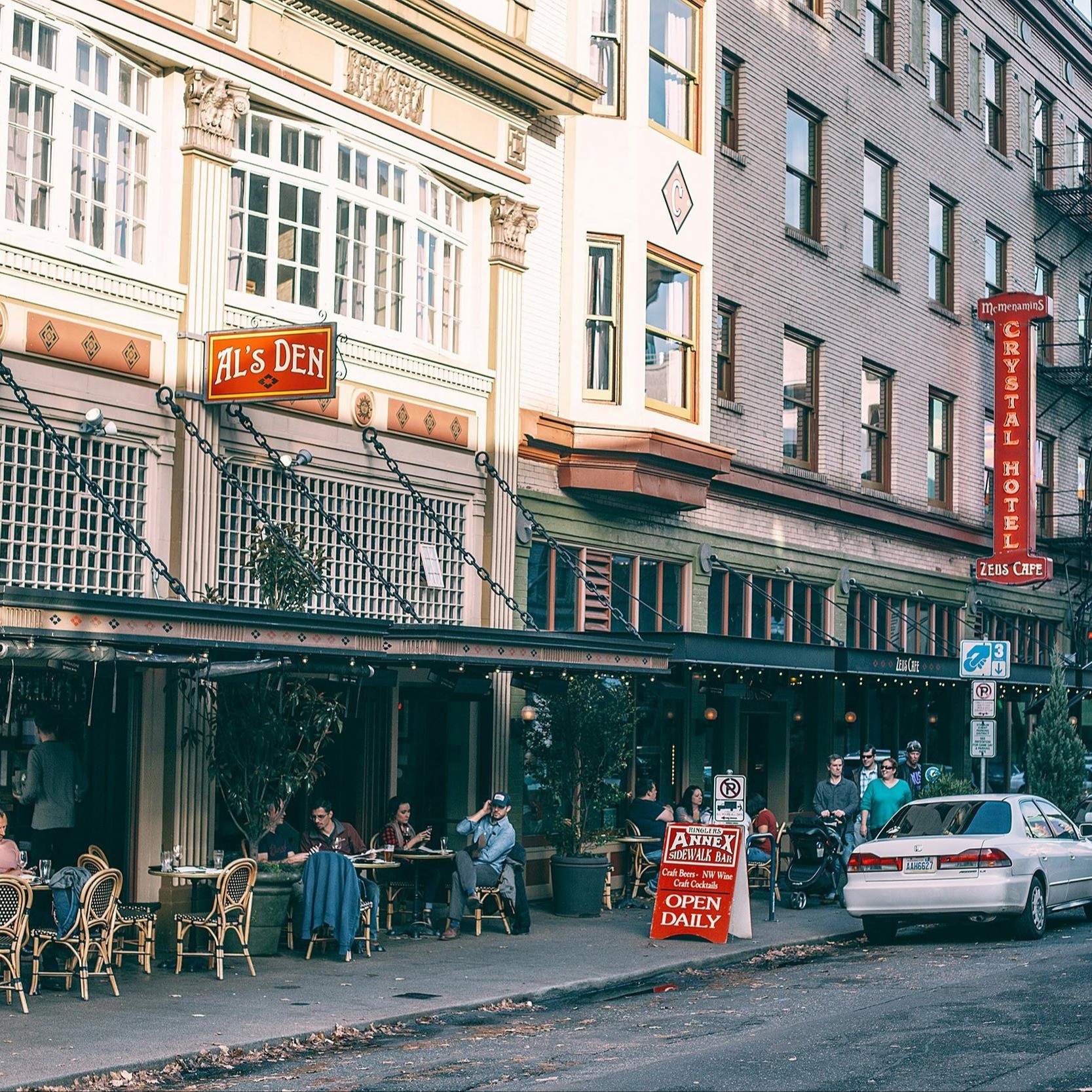 people sitting and walking outside of a restaurant 