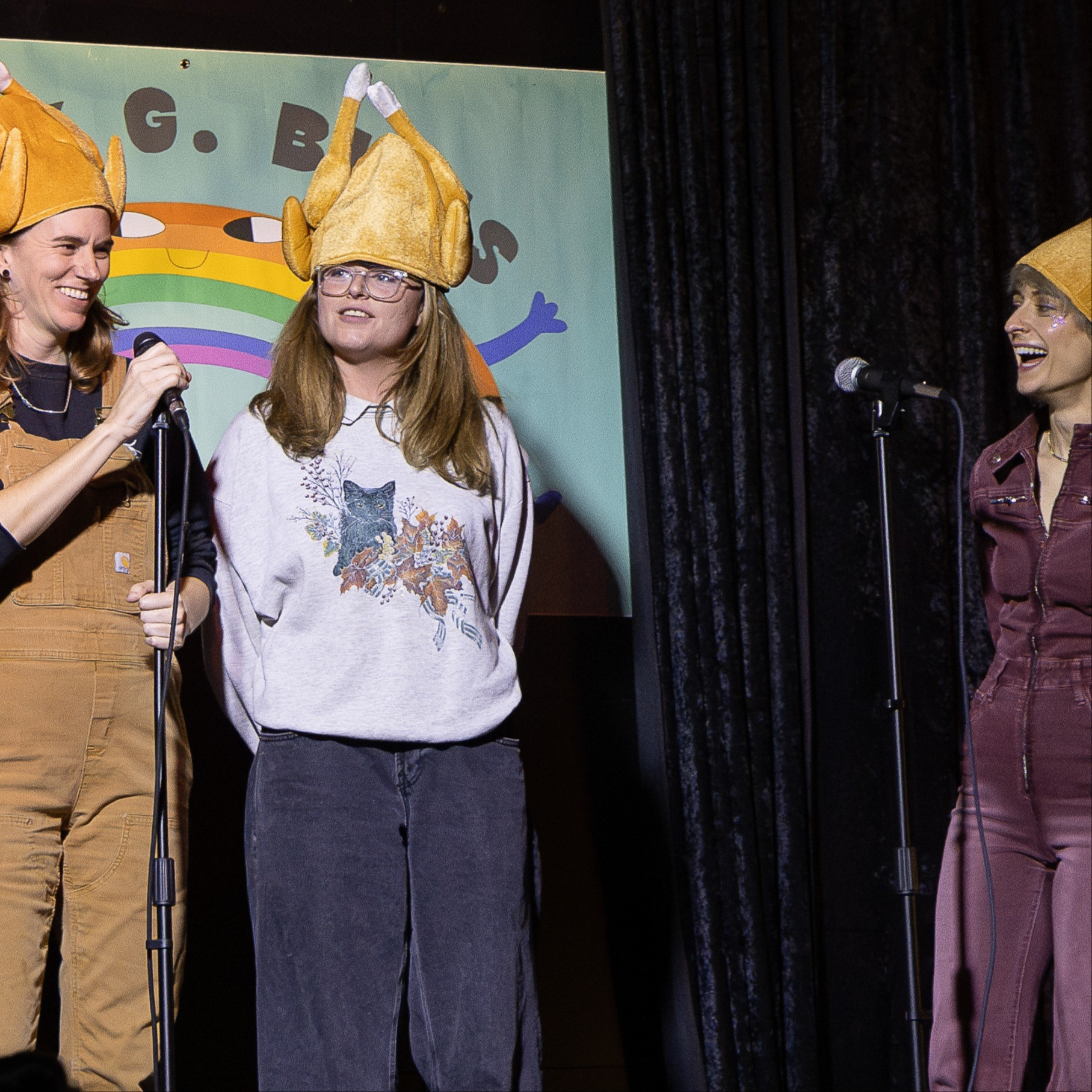 people wearing turkey hats on stage in front of mic stands