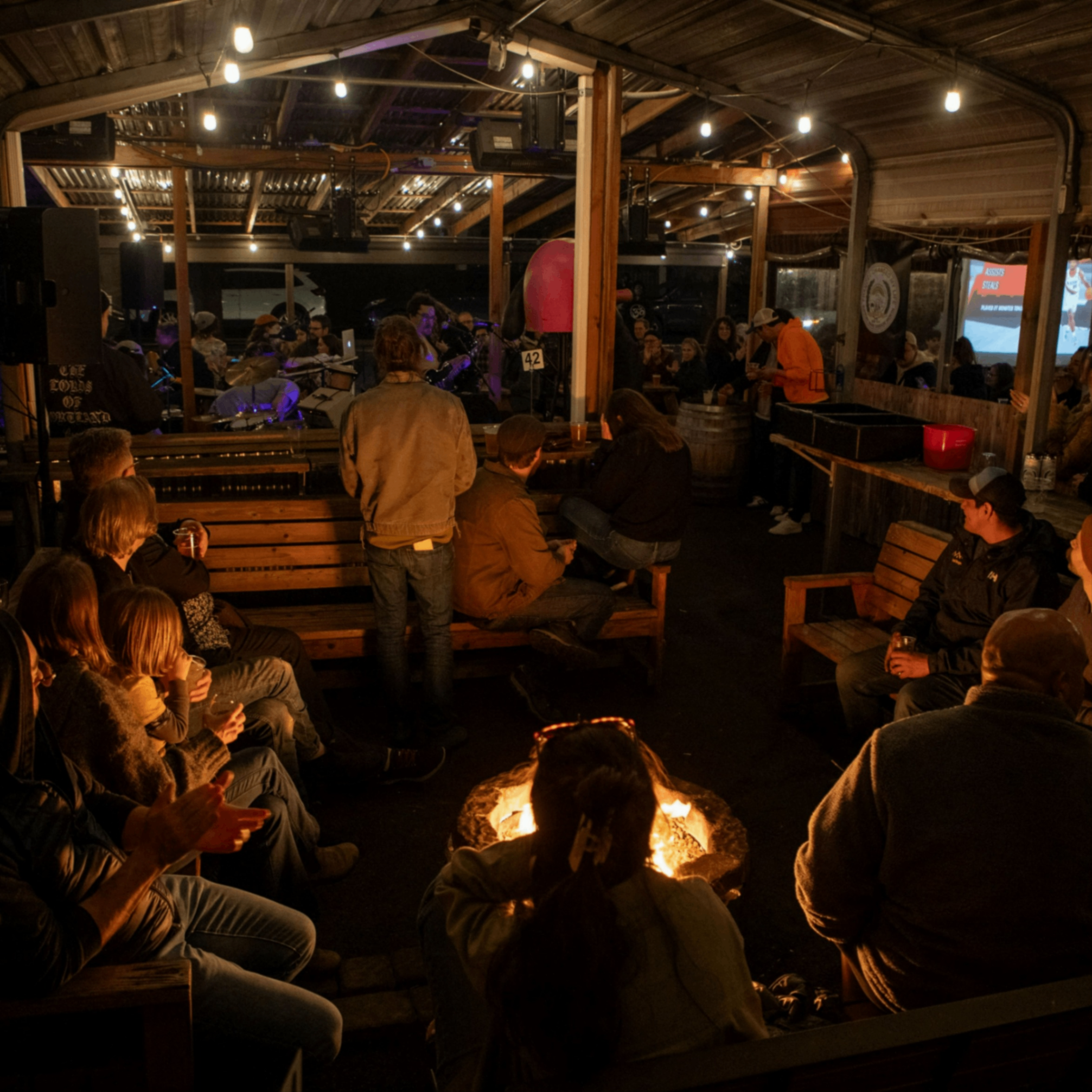 people sitting around an outdoor firepit