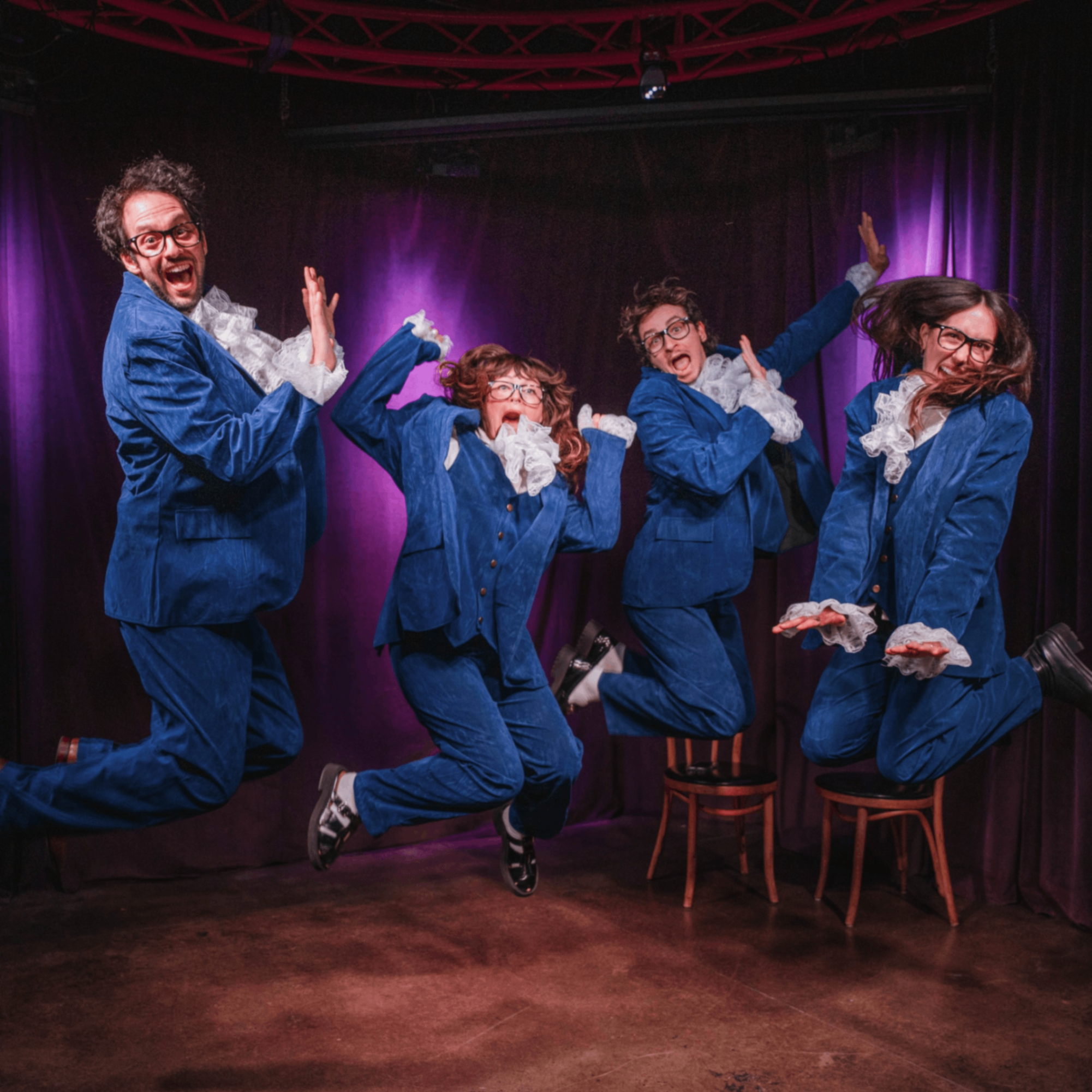 people in blue suits jumping on stage