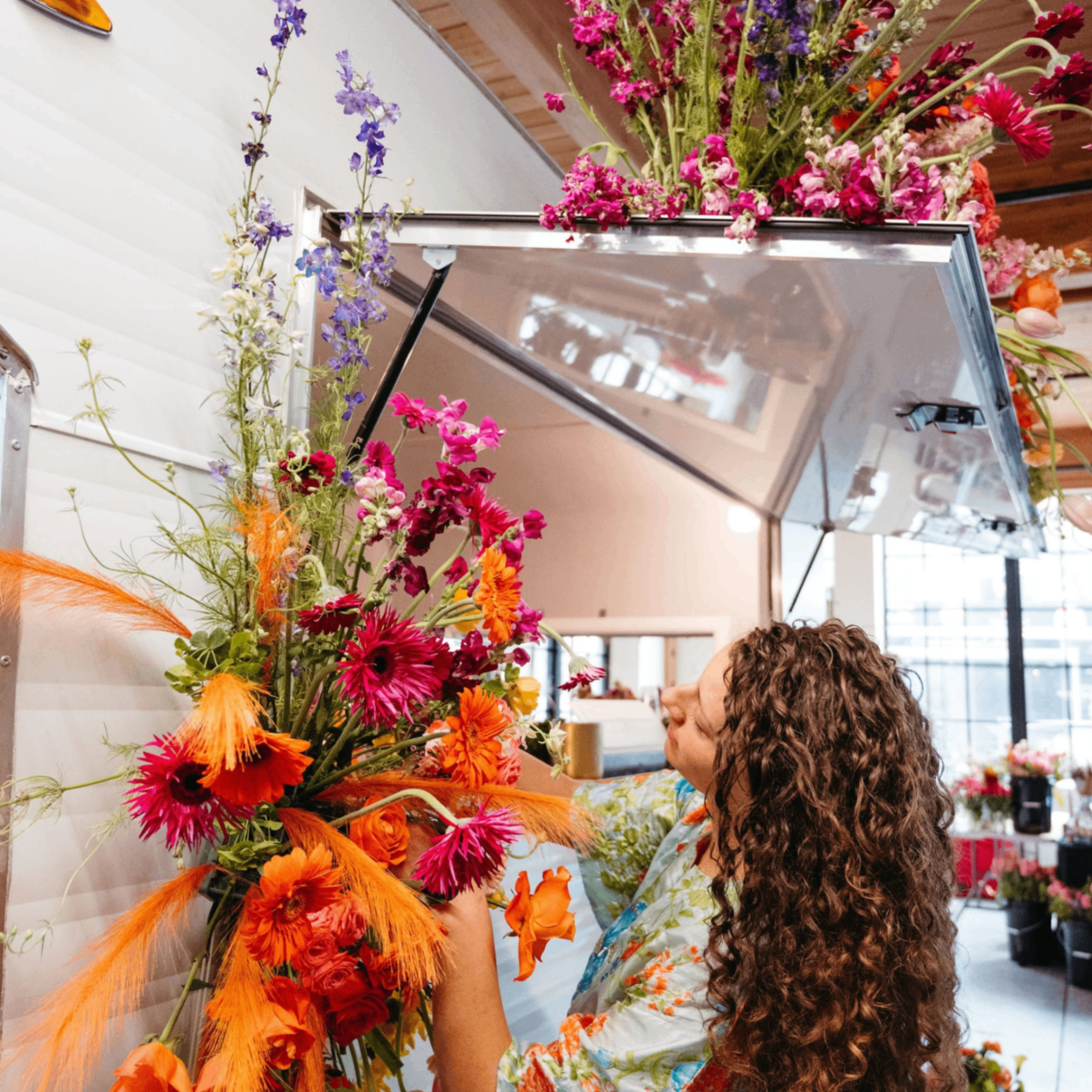 a person hanging a large flower arrangement on a wall