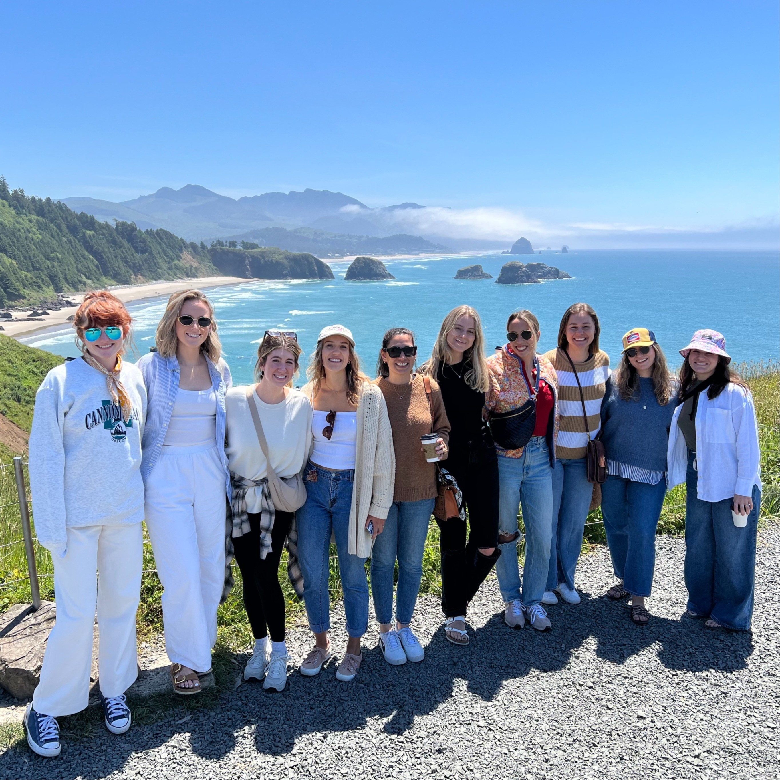 a line of tourists pose in front of a beach view