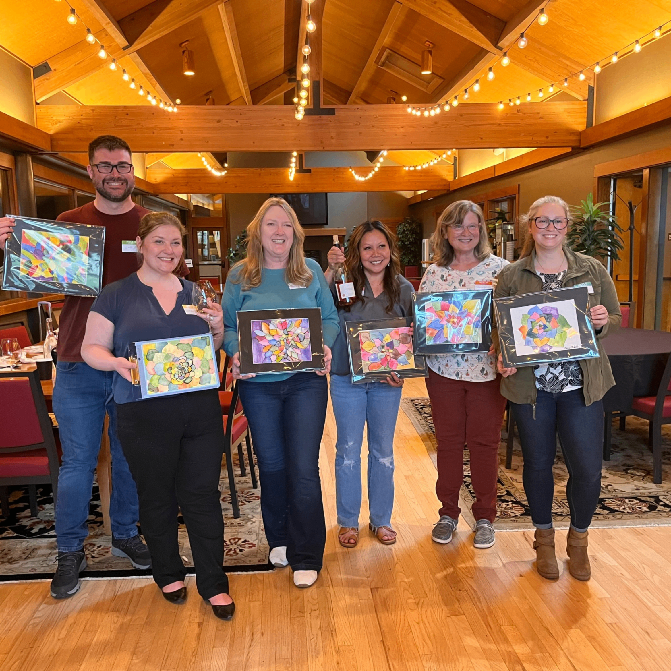 people holding up their watercolor paintings