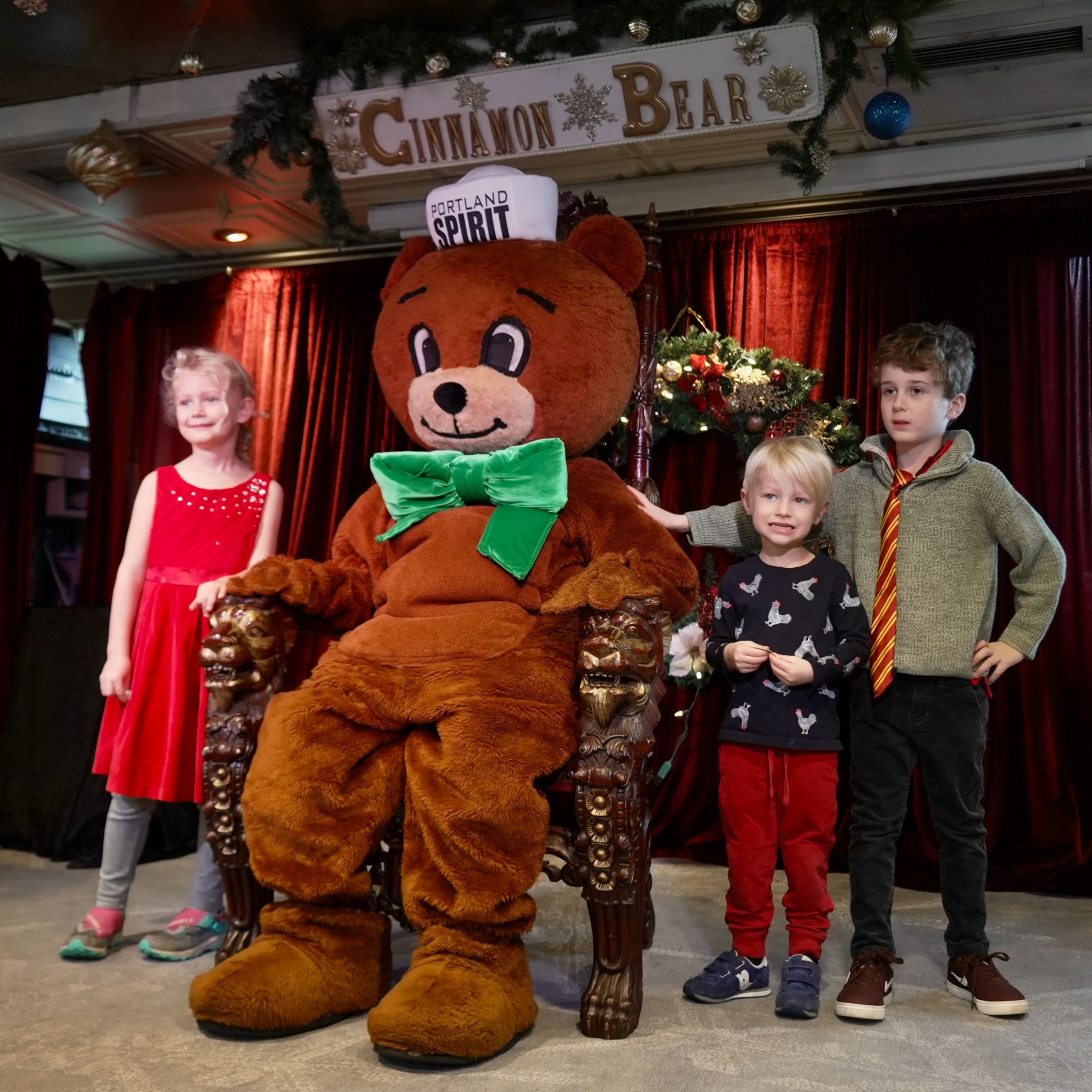 kids pose for photos with a giant teddy bear