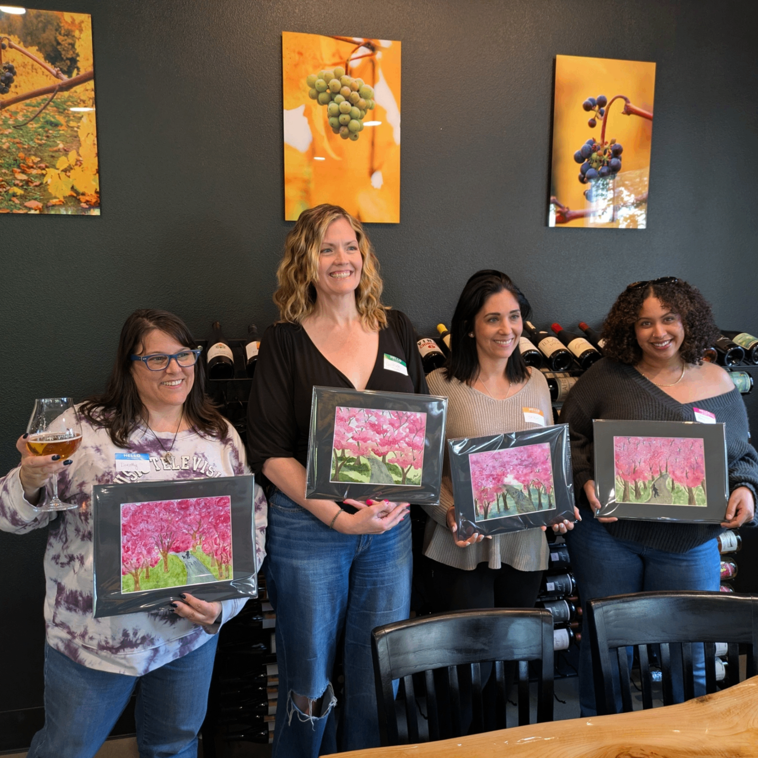 people holding up their watercolor paintings 