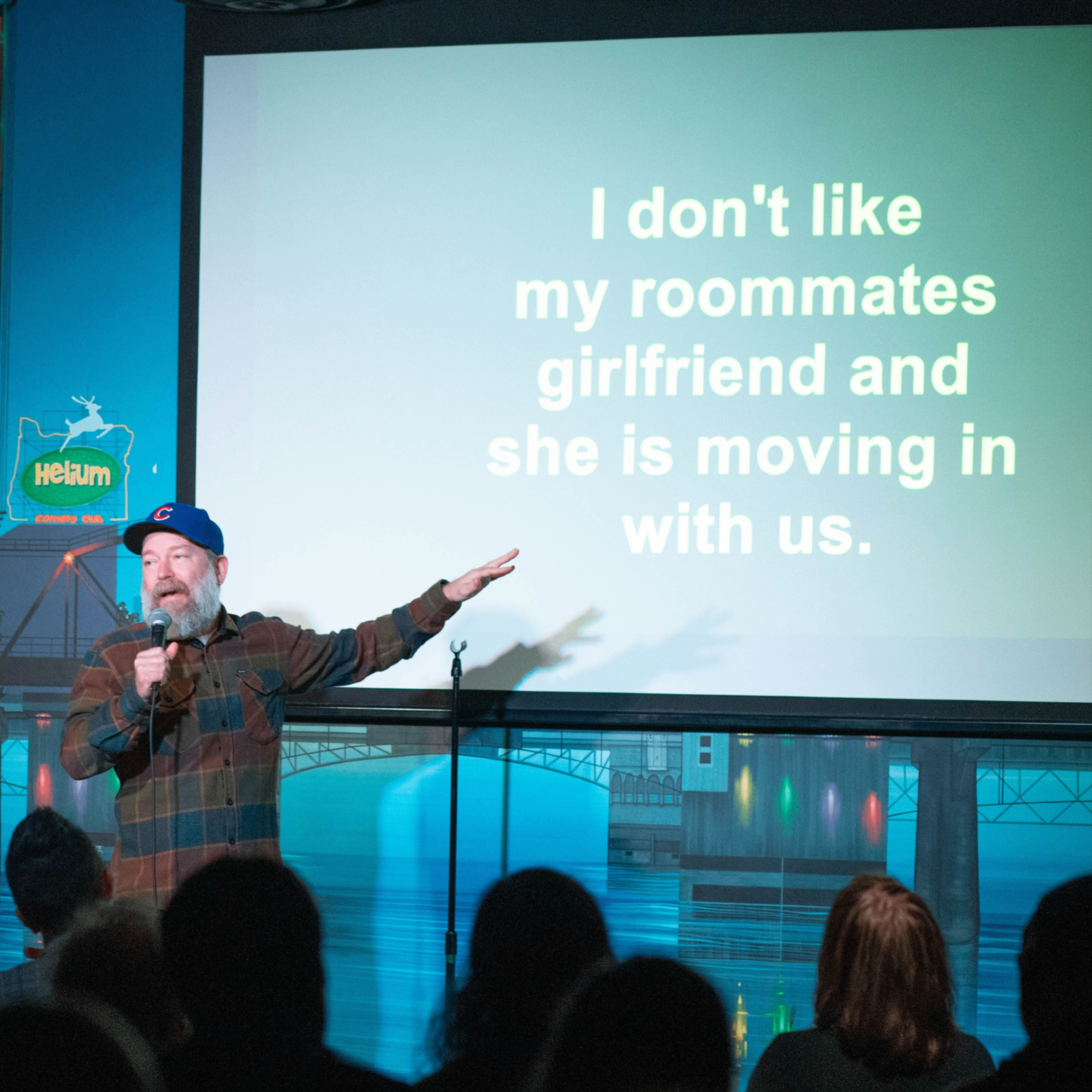 man speaking into a microphone on stage