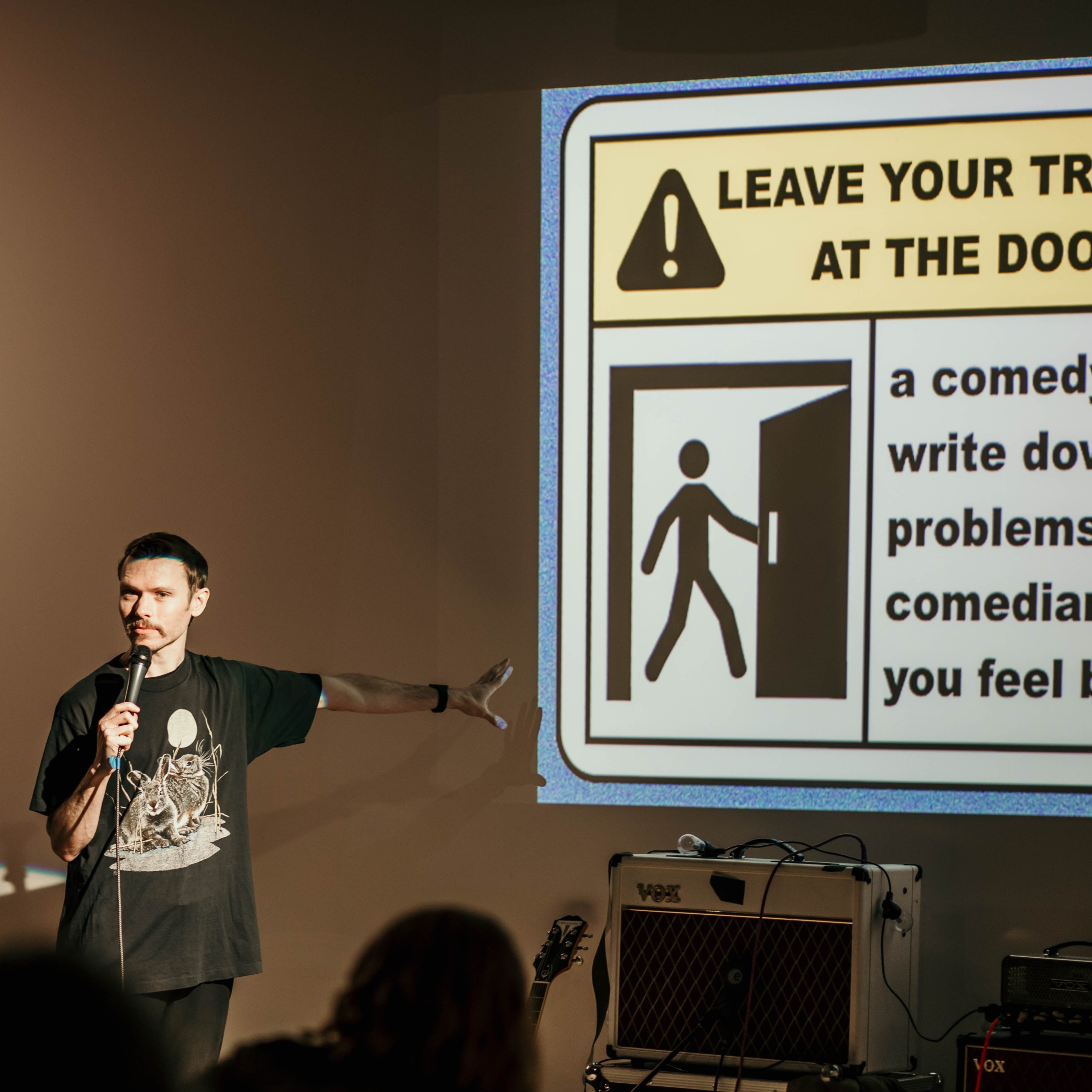 person on stage speaking into a microphone