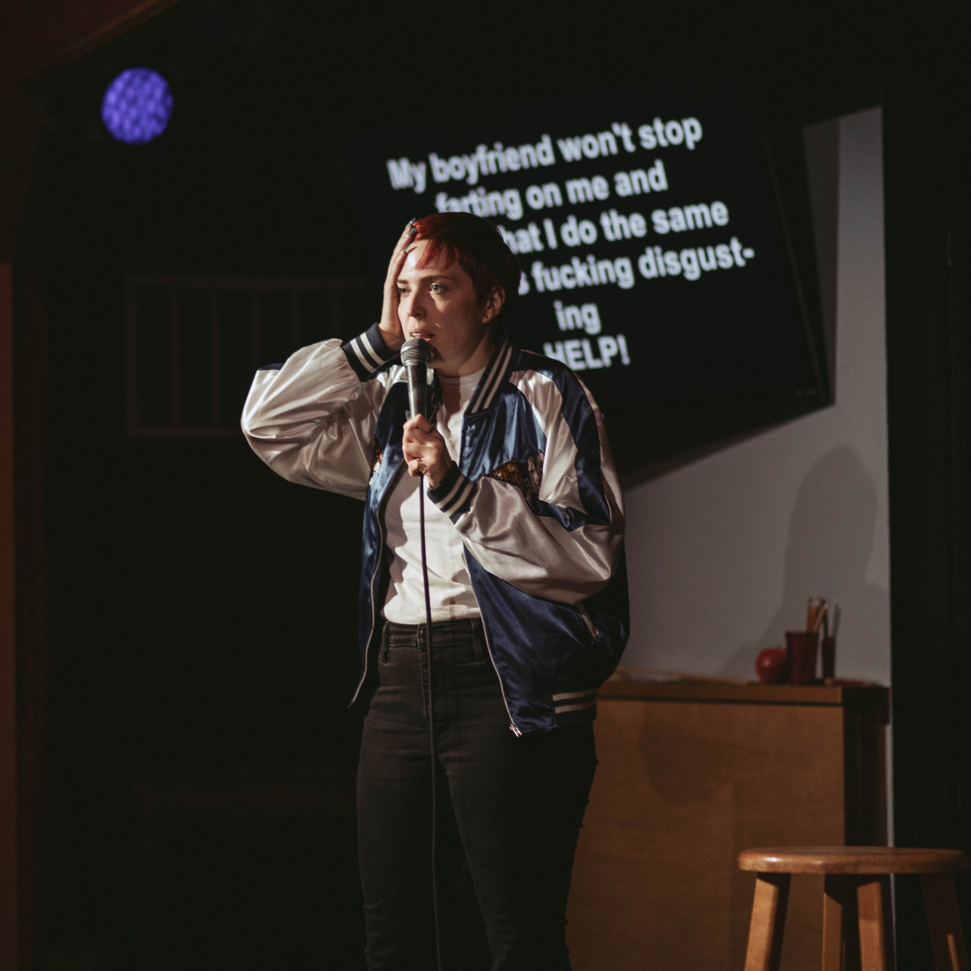 person on stage speaking into a microphone