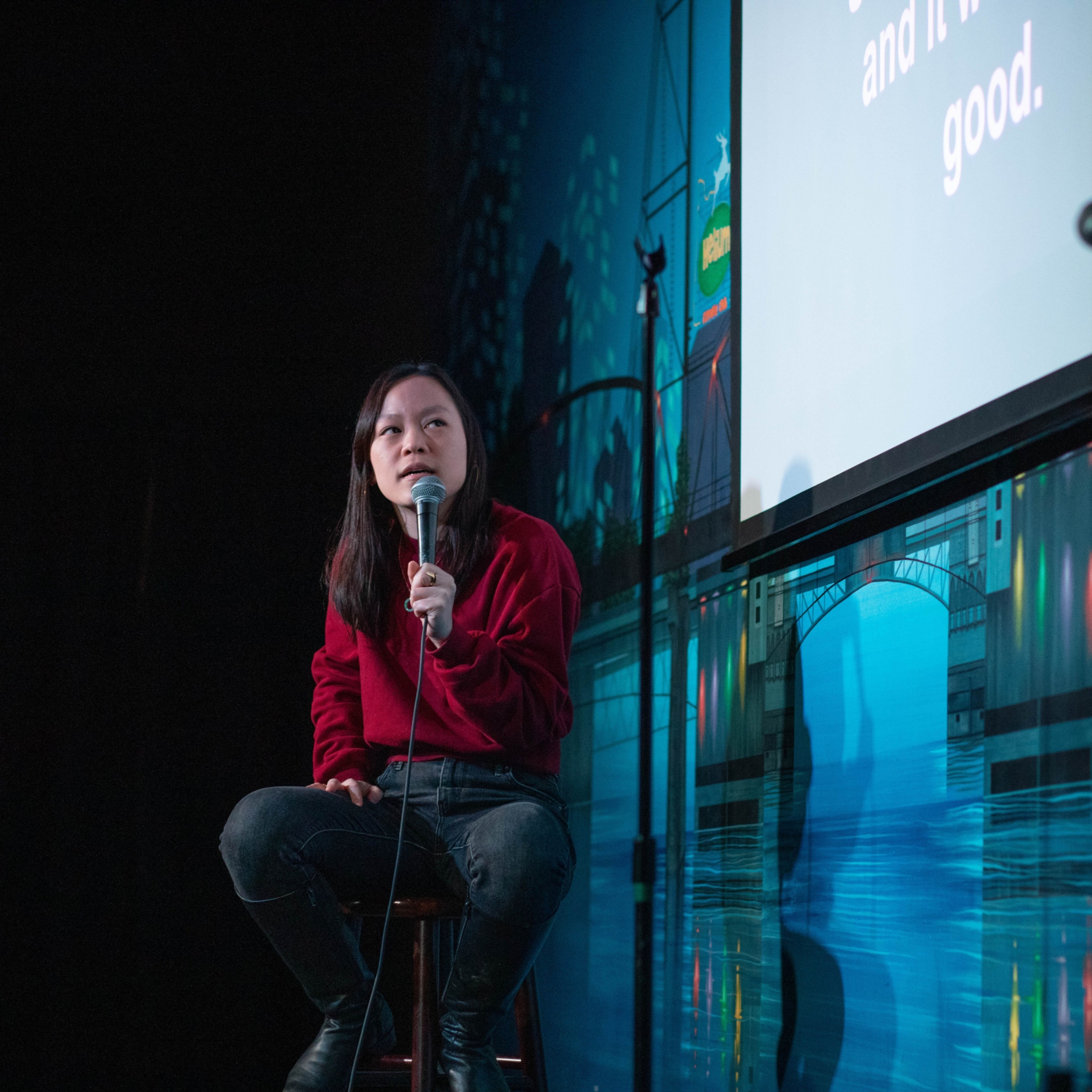 person on stage speaking into a microphone