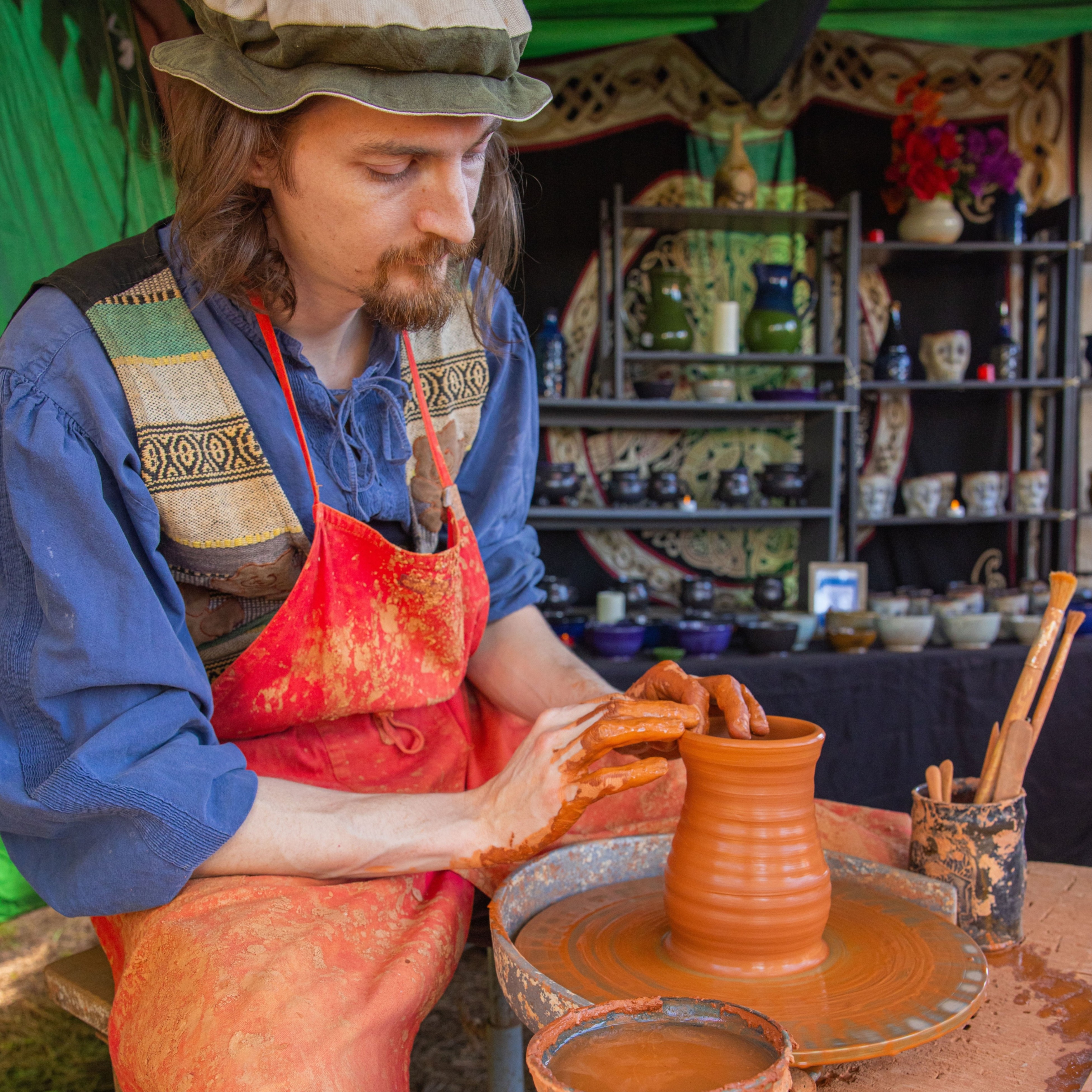 a person throwing a pot on a wheel