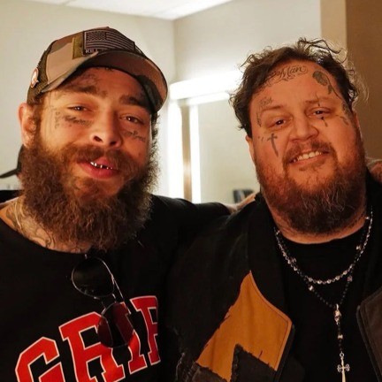 two people with tattoos smile side by side