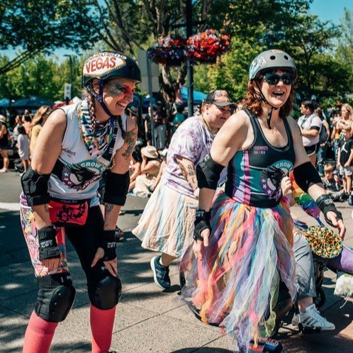 participants in a pride parade with crowd watching from sidelines