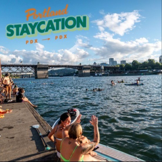 people sitting on a dock waving at people swimming and kayaking in a river