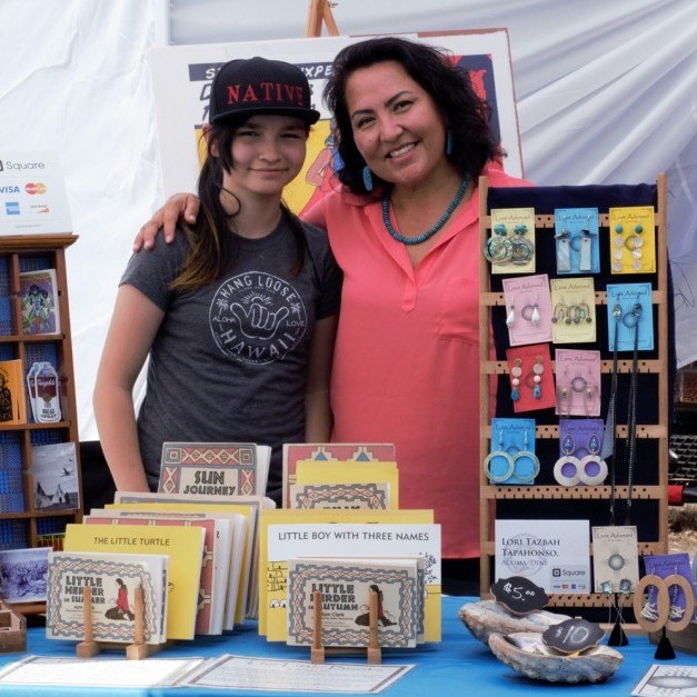 two people stand in front of items on display for sale