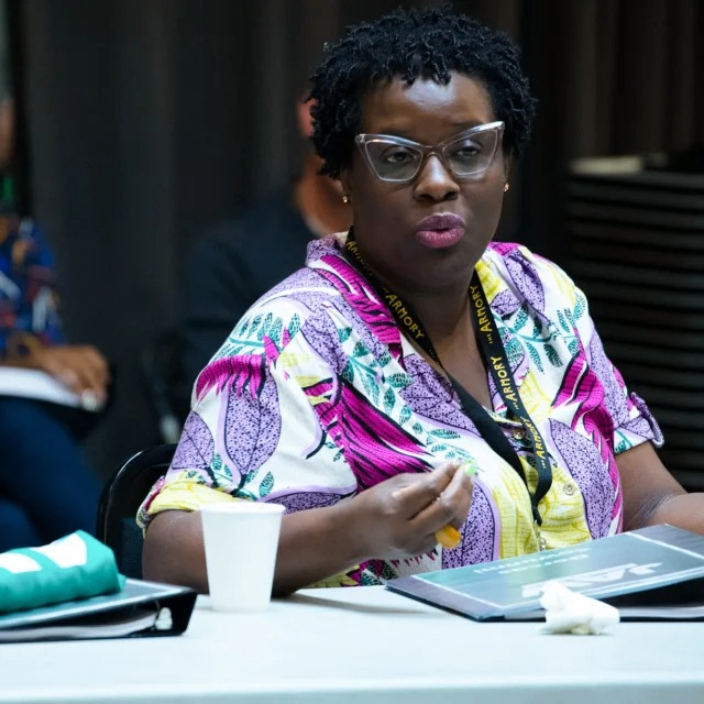 a woman speaking while sitting at a table