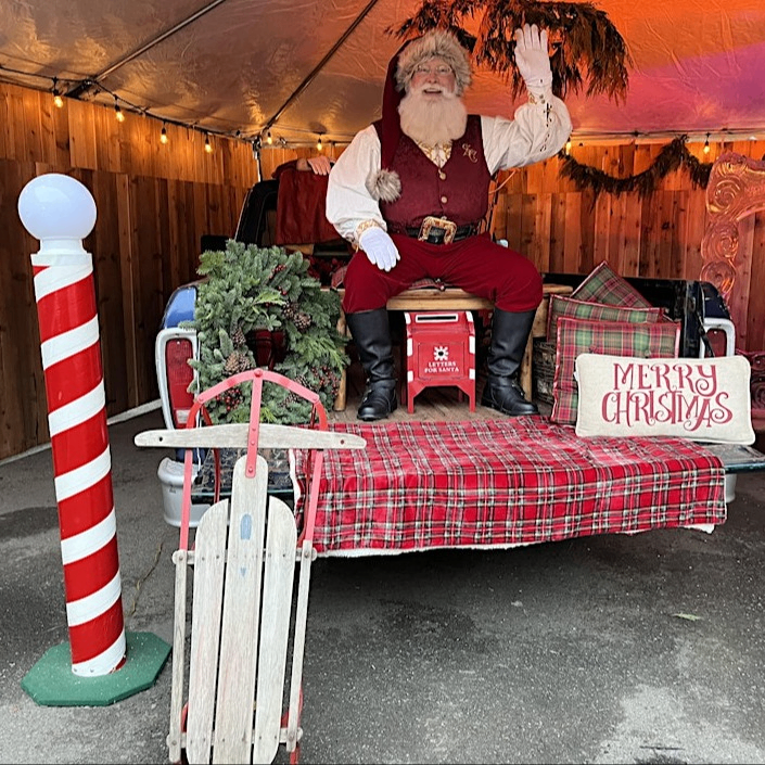 santa sitting on a chair surrounded by festive decorations