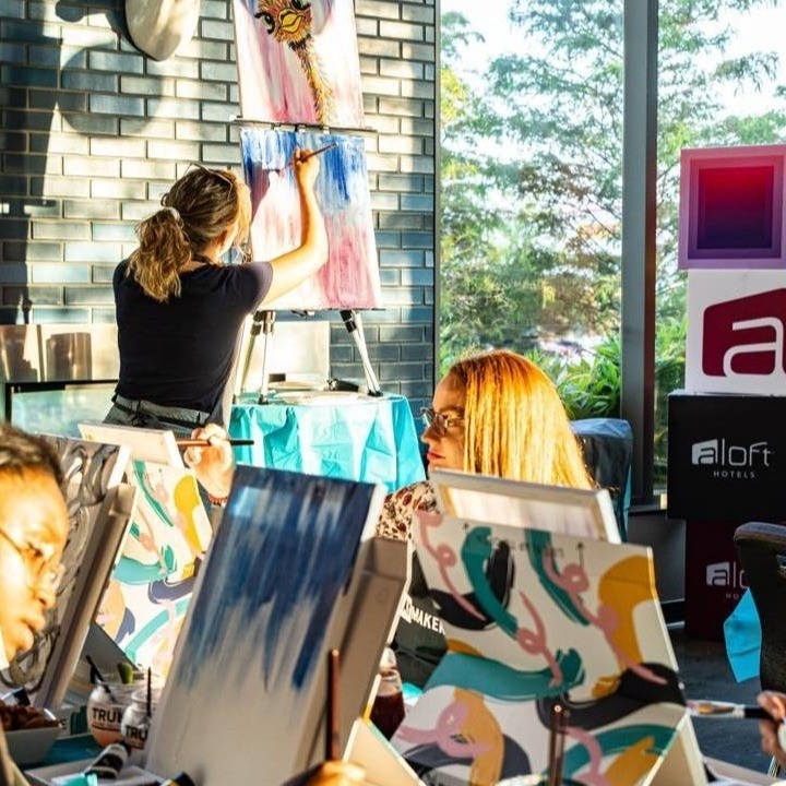 people painting on canvases