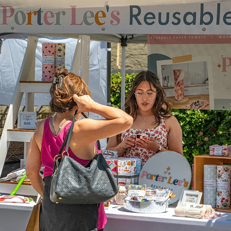 people at a sales booth in an outdoor market