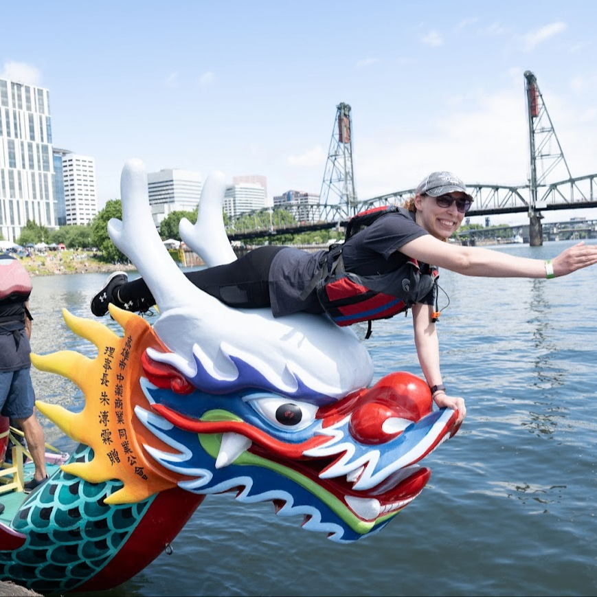 a person reaching from the head of a dragonboat