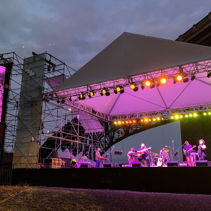 a band performs on lit up outdoor stage